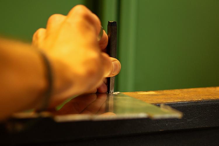 Einblick in die Goldschmiede-Werkstatt, beim Punzieren eines Silberbleches