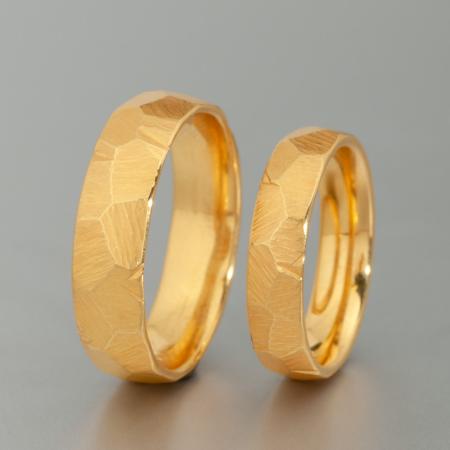 Handgefertigte Trauringe aus 900 Gold mit Finnen-Hammerschlag-Oberfläche, detailreiche Nahaufnahme